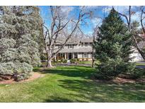 Charming two-story home featuring a landscaped yard and inviting front porch, perfect for enjoying the outdoors at 4 Brookside Dr, Greenwood Village, CO 80121