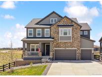 Beautiful two-story home boasts a stone facade, three-car garage, and a welcoming front porch at 3038 Blithe Pt, Castle Rock, CO 80108