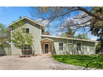 Charming home with light green siding and a welcoming stone-accented entrance, plus mature trees on a grassy lot at 185 S Hoyt St, Lakewood, CO 80226