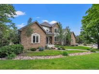Charming home with stone accents, mature trees, and manicured lawn in a desirable neighborhood at 1999 Champions Cir, Castle Rock, CO 80104