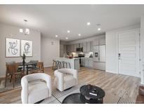 Open concept living room with modern kitchen, dining area, and stylish furnishings at 487 Interlocken Blvd # 307, Broomfield, CO 80021