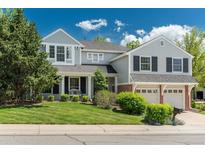 Charming two-story home with manicured lawn and a two-car garage, accented by mature trees and shrubs at 7076 S Niagara Ct, Centennial, CO 80112