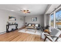 Bright living room features hardwood floors, comfy seating, and large windows at 6963 S Albion St, Centennial, CO 80122