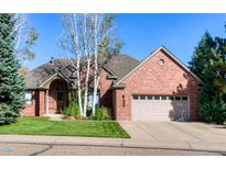 Charming single-Gathering home featuring a brick exterior, well-manicured lawn, and attached two-car garage at 2425 Waneka Lake Trl, Lafayette, CO 80026