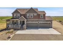 Charming two-story home features a covered porch, three-car garage, and stone accents at 49346 E County Road 6, Bennett, CO 80102