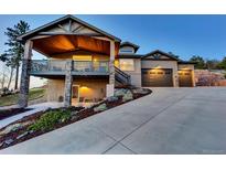 Beautiful two-story home featuring a deck with stone supports and a spacious three-car garage at 20243 High Pines Dr, Monument, CO 80132