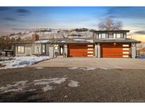 House exterior with three car garage and snowy yard at 16587 W 53Rd Way, Golden, CO 80403