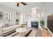 Inviting living room features a cozy fireplace and stylish decor with a comfortable white couch and modern accents at 7434 Singing Hills Ct, Boulder, CO 80301