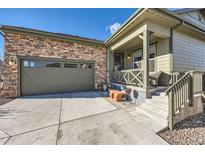 House exterior featuring a stone and siding facade, attached garage, and a welcoming front porch at 4051 Happy Hollow Dr, Castle Rock, CO 80104
