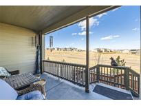 Inviting covered porch with seating that offers scenic views of the surrounding neighborhood and the open landscape beyond at 4051 Happy Hollow Dr, Castle Rock, CO 80104