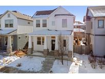 Two-story white house with stone accents and a front porch at 10350 E 57Th Pl, Denver, CO 80238