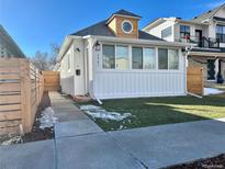 Charming home featuring a unique cupola, pristine white siding, and a well-maintained front yard at 2461 Depew St, Edgewater, CO 80214
