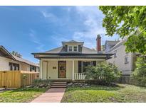 Charming home with a well-maintained yard, red stone pathway, and inviting covered porch at 1012 Fillmore St, Denver, CO 80206