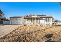 Charming single story home featuring stone accents, a covered porch, and a spacious attached two car garage at 6369 W 69Th Ave, Arvada, CO 80003