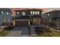 Charming two-story home boasts stone accents and a cozy front porch, set against a colorful evening sky at 420 Pleades Pl, Erie, CO 80516