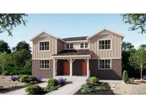 Charming two-story home featuring brick accents, a welcoming front porch, and beautifully landscaped surroundings at 24116 E 53Rd Dr, Aurora, CO 80019