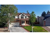 Charming two-story home featuring a brick facade, well-maintained lawn, and an attached two-car garage at 941 E 130Th Cir, Thornton, CO 80241