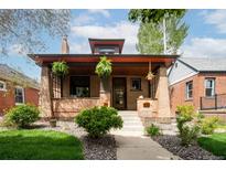 Charming brick home with a covered front porch and manicured landscaping at 1169 Cook St, Denver, CO 80206