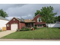 Charming two-story home featuring a well-manicured front yard, attached garage, and tasteful landscaping at 13168 W 62Nd Dr, Arvada, CO 80004