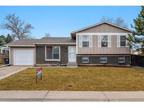 Charming bi-level home with a well-manicured lawn and a classic brick and siding facade at 2123 S Joplin Way, Aurora, CO 80013