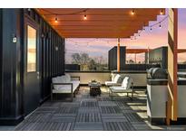 Relaxing rooftop deck features stylish seating, grill, wooden flooring, and string lights for outdoor enjoyment and entertaining at 3036 Wilson Ct # 5, Denver, CO 80205