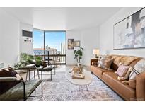 Bright living room featuring modern decor, large windows with city views, and stylish furnishings at 1625 Larimer St # 1806, Denver, CO 80202