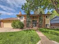 Charming brick two-story home featuring mature trees, manicured lawn, and inviting front entrance at 6160 Taft Ct, Arvada, CO 80004