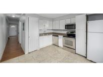 Bright kitchen features stainless steel appliances and white cabinets at 1628 Chester St, Aurora, CO 80010