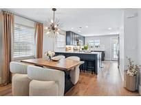 Bright dining area with modern light fixture, hardwood floors, and seating for six at 796 Ivanhoe St, Denver, CO 80220
