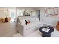 Bright living room featuring a modern sofa, wood floors, a dining area, and stylish decor at 1020 Stuart, Denver, CO 80204