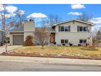 Charming home featuring a well-maintained lawn, painted brick, and a classic two-story design at 6864 Balsam St, Arvada, CO 80004