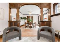 Inviting dining room with hardwood floors, crystal chandelier, built-in hutch, and stylish gray chairs at 1220 S Vine St, Denver, CO 80210
