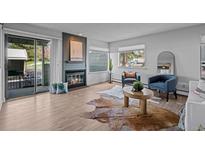 Bright living room featuring a fireplace, modern furniture, wood floors, and a sliding door to the outside at 6844 Countryside Ln # 284, Niwot, CO 80503