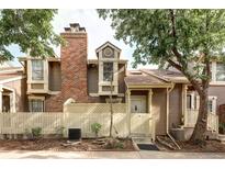 Charming home featuring a brick chimney, privacy fence, and mature trees in a tranquil setting at 2082 S Helena St # C, Aurora, CO 80013