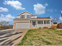 Charming two-story home featuring a welcoming front porch and well-maintained lawn on a beautiful day at 9515 Bexley Dr, Highlands Ranch, CO 80126
