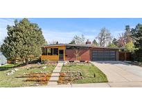 Charming brick home with a well-manicured front yard, mature trees, and a two-car garage at 3035 E Maplewood Ave, Centennial, CO 80121