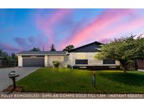 Charming single-story home featuring a well-maintained lawn, brick facade, and attached garage with a beautiful sunset backdrop at 13010 W 6Th Pl, Golden, CO 80401