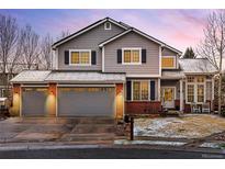 Charming two-story home featuring a three-car garage, well-maintained lawn, and welcoming front porch at 6071 Russell Ln, Arvada, CO 80403