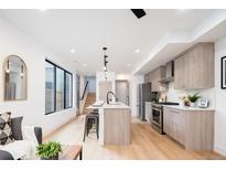Modern kitchen features stainless appliances, a kitchen island, and bright natural light at 3433 Lawrence St # 1, Denver, CO 80205