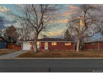 Charming single-story brick home featuring mature trees and a well-maintained front yard at 6532 S Ogden St, Centennial, CO 80121