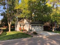 Charming single-Gathering home with a well-manicured lawn, mature trees, and an attached two-car garage at 995 W Peakview Cir, Littleton, CO 80120