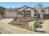 Charming home features a well-manicured front yard and a two-car garage, enhancing curb appeal and functionality at 10443 W 84Th Pl, Arvada, CO 80005