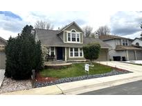 Charming two-story home with well-manicured lawn and inviting front patio area at 13474 W 65Th Dr, Arvada, CO 80004