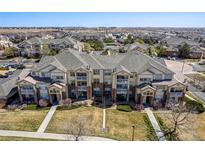 Beautiful condo building featuring a well-maintained lawn and manicured landscaping at 5705 N Genoa Way # 206, Aurora, CO 80019