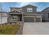 Charming two-story home with stone accents, covered porch, three-car garage, and landscaped front yard at 3008 Blithe Pt, Castle Rock, CO 80108