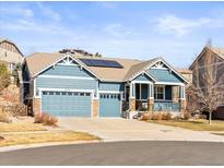 Charming two-story home with a three-car garage and solar panels on the roof under a blue sky at 23327 E Ottawa Dr, Aurora, CO 80016