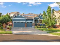 Charming blue home featuring a well-manicured lawn, mature trees, and a three car garage at 23327 E Ottawa Dr, Aurora, CO 80016