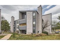 Exterior view of the building with modern gray facade and landscaped grounds at 9867 E Peakview Ave # E1, Englewood, CO 80111