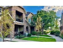 Beautiful stone townhome exterior with manicured lawn and a lovely walkway to your front door at 15362 W 66Th Ave # D, Arvada, CO 80007