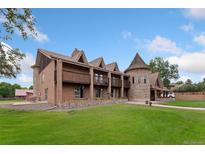 Expansive brick home with a distinctive turret and well-manicured lawn at 11485 Pecos St, Denver, CO 80234